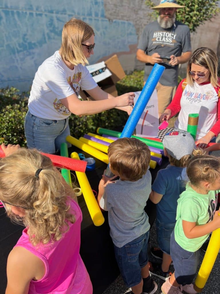 young woman helping kids make arts and crafts on Star Wars Day in downtown Panama City