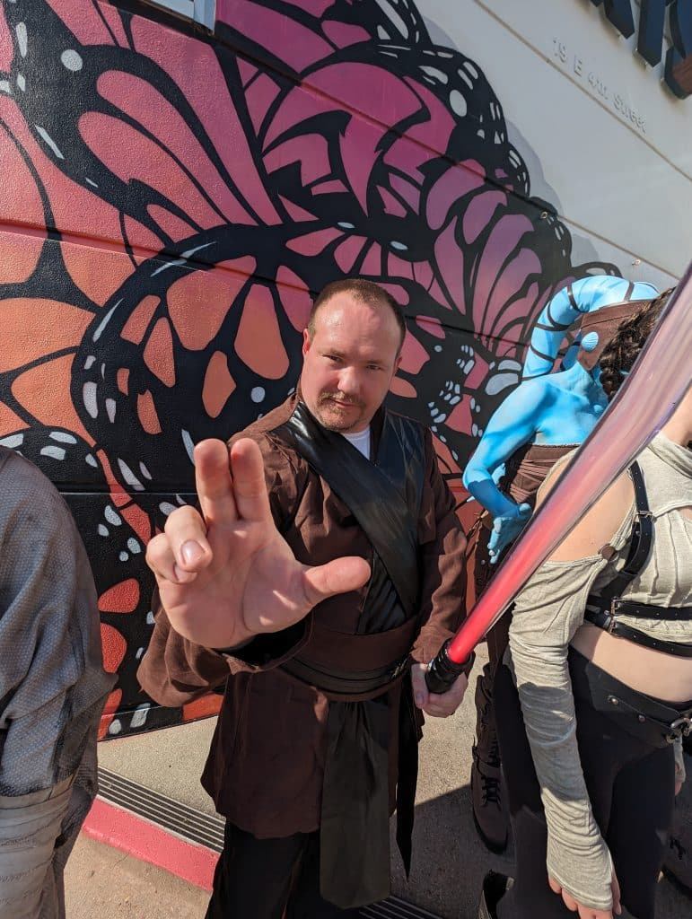 person holding up star wars symbol and a light saber on Star Wars Day in Panama City