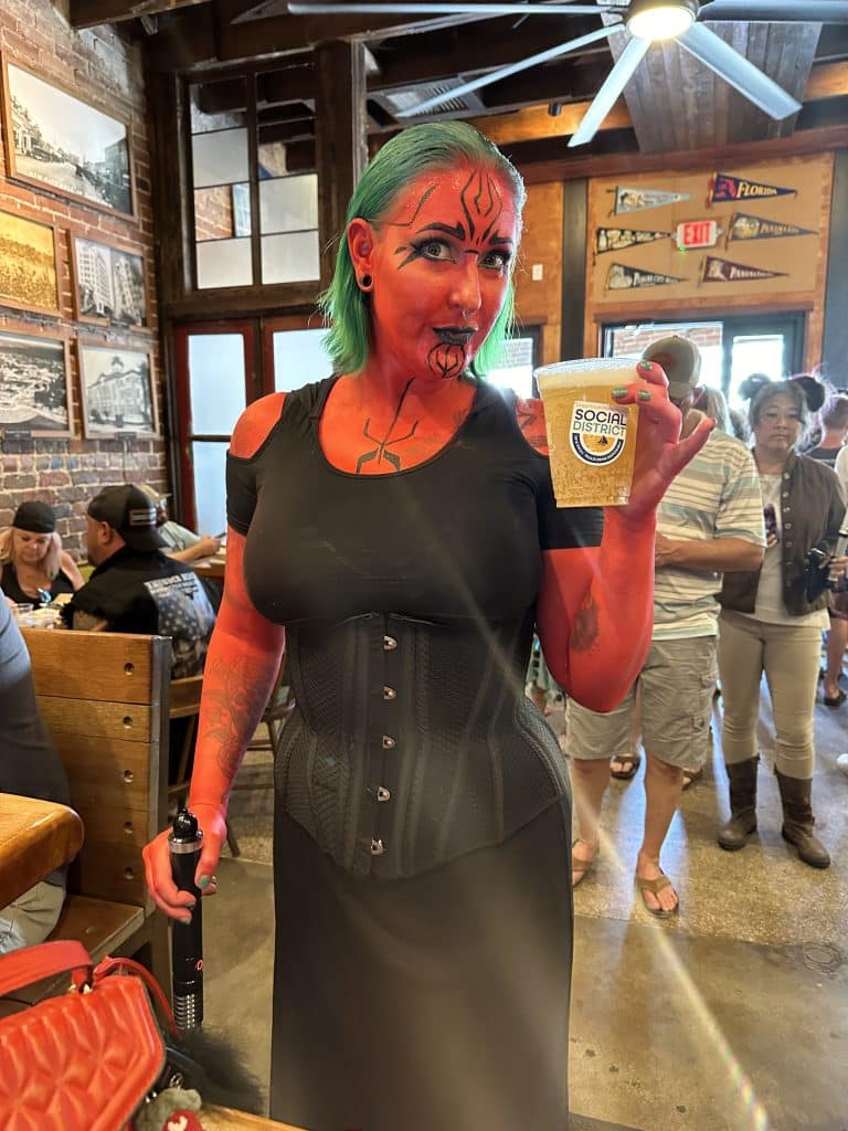 Woman dressed as a character from Star Wars holding a beer at History Class Brewing in downtown Panama City on Star Wars Day